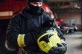 Portrait of firefighter in protective uniform that holds cute little black cat Royalty Free Stock Photo