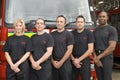 Portrait of firefighters standing by a fire engine