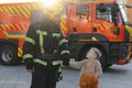Portrait of a fireman and a little boy with a teddy bear. Royalty Free Stock Photo