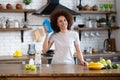 Portrait of fit african american woman in sportswear at the kitchen holding shaker with whey protein or fresh water, work out at Royalty Free Stock Photo