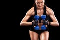 Sporty beautiful woman with dumbbell exercising at black background to stay fit. Crossfit workout motivation.