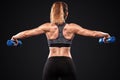 Sporty and fit beautiful woman with dumbbell exercising at black background to stay fit. Fitness workout motivation.