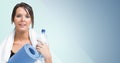 Portrait of fit woman standing with exercise mat and water bottle Royalty Free Stock Photo