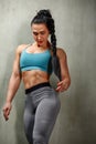 Portrait of a fit young woman posing wearing a sports bra against gray background. Determined athlete in the studio Royalty Free Stock Photo