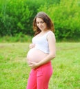 Portrait fitness pregnant woman outdoors in summer