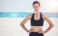 Portrait, fitness and serious woman at a beach for training, sports and exercise, running and workout in nature. Ocean