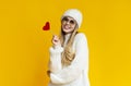 Portrait of flirting winter girl holding red heart card