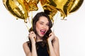 Portrait of flirty attractive winking curly woman with golden balloons