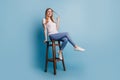 Portrait of flirty dreamy lady sit chair play curl wear white t-shirt isolated on blue color background