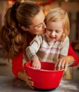 Flour smeared mother and baby making christmas cooki