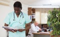 Portrait of a focused african american male doctor standing with medical documents in the office