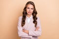 Portrait of focused concentrated lady crossed arms look camera isolated on beige color background