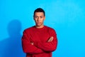 Portrait of focused concentrated young man crossed arms posing empty space isolated on blue color background Royalty Free Stock Photo