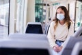 Portrait of a focused girl in a protective mask riding on public transport