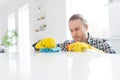 Portrait of focused minded guy do chores want rub dust table hard to clean use chemical bottle spray wear casual