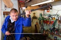 Skilled craftsman of weapons workshop cleaning rifle barrel with ramrod