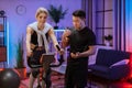 Portrait of young female wearing sport bra and using exercise bike and her trainer asian male. Royalty Free Stock Photo