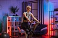 Portrait of focused young female wearing sport bra and using exercise bike. Royalty Free Stock Photo