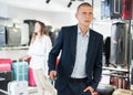 Portrait of a focused man with a travel suitcase, standing in a store