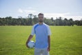 Football player holding soccer in the ground Royalty Free Stock Photo