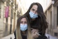 Portrait of two girls in medical masks having fun in the city