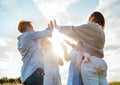 Portrait of four cheerful laughing women holding hands Up making High Five during outdoor walking. They looking at the camera.