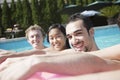 Portrait of four friends in the pool with an inflatable raft