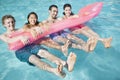 Portrait of four friends in the pool with an inflatable raft