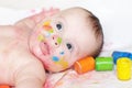 Portrait of four-months baby with multi-colored paints