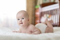 Portrait of four months old baby on the bed in nursery room Royalty Free Stock Photo