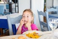 Little girl making faces with paella dish in restaurant Royalty Free Stock Photo