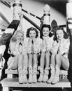 Portrait of four young women sitting on steps in western clothing