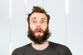 Portrait freak bearded shaggy surprised man with long hair before haircut in barbershop with open mouth and wide eyes Royalty Free Stock Photo