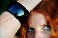Portrait of a freckled redhead woman with black bracelet with reflection