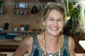 Portrait of a french blonde mature woman smiling at her store, entrepreneur concept