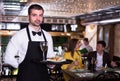 Portrait of frendly male waiter who is standing with tray Royalty Free Stock Photo