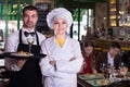Portrait of frendly waiter and woman cook who are standing with tray Royalty Free Stock Photo
