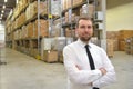 portrait friendly businessman manager in suit on the phone in the warehouse of a company
