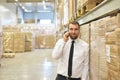 portrait friendly businessman manager in suit on the phone in the warehouse of a company