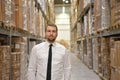 portrait friendly businessman manager in suit working in the warehouse of a company