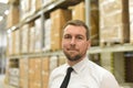 portrait friendly businessman manager in suit working in the warehouse of a company