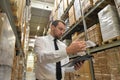 portrait friendly businessman manager in suit working in the warehouse of a company - control of inventories