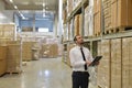 portrait friendly businessman manager in suit working in the warehouse of a company - control of inventories