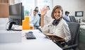 Portrait of friendly businesswoman holding pen and notebook and waving hand to camera at office. Royalty Free Stock Photo