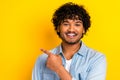 Portrait of friendly cheerful man beaming smile indicated finger empty space ad isolated on yellow color background