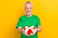 Portrait of friendly cheerful man toothy smile arms hold give you heart figure giftbox isolated on yellow color Royalty Free Stock Photo