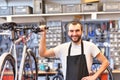 Portrait of a friendly and competent bicycle mechanic in a workshop repairs a bike Royalty Free Stock Photo