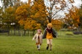 Portrait of friendly cute couple kids boy and girl running and playing in autumn park. Kids wearing casual stylish
