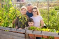 Portrait of friendly family with children at the fence of garden