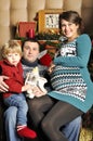 Portrait of a friendly family with pregnant woman during Christmas time